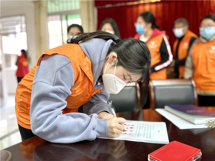 3志愿隊成員在請戰(zhàn)書上簽名04.jpg