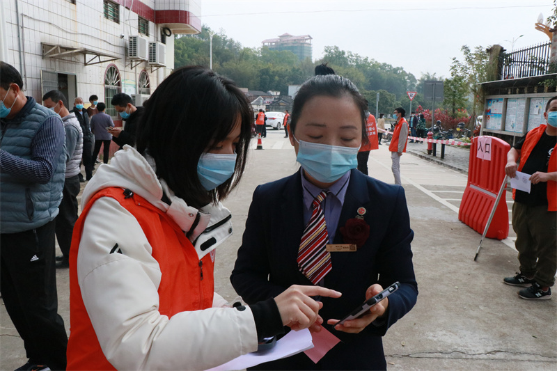 選調(diào)生陳名楚檢查群眾“粵康碼”和“行程碼”，幫助群眾生成葵花碼.JPG