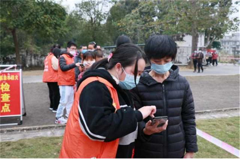 圖五：黃家寶在核酸現場幫助群眾完成信息登記，生成葵花碼（攝影者：劉綺婷，單位：三合鎮人民政府）.jpg