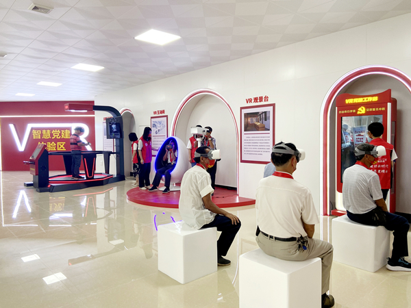 圖為：新黨員陪老黨員共同使用VR黨建設(shè)備體驗(yàn)_副本.jpg