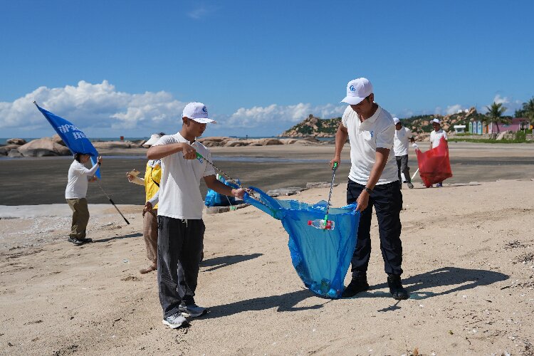 圖為青年志愿者在收拾海灘上的垃圾1.jpg