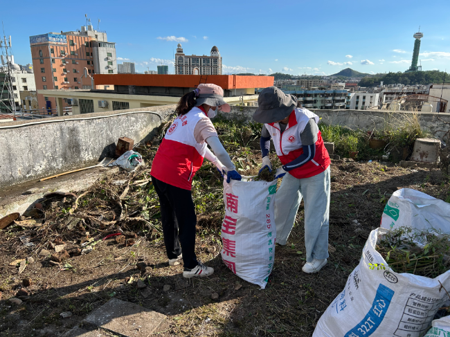 大灣集團(tuán)黨員干部清理居民樓頂雜草垃圾.jpg