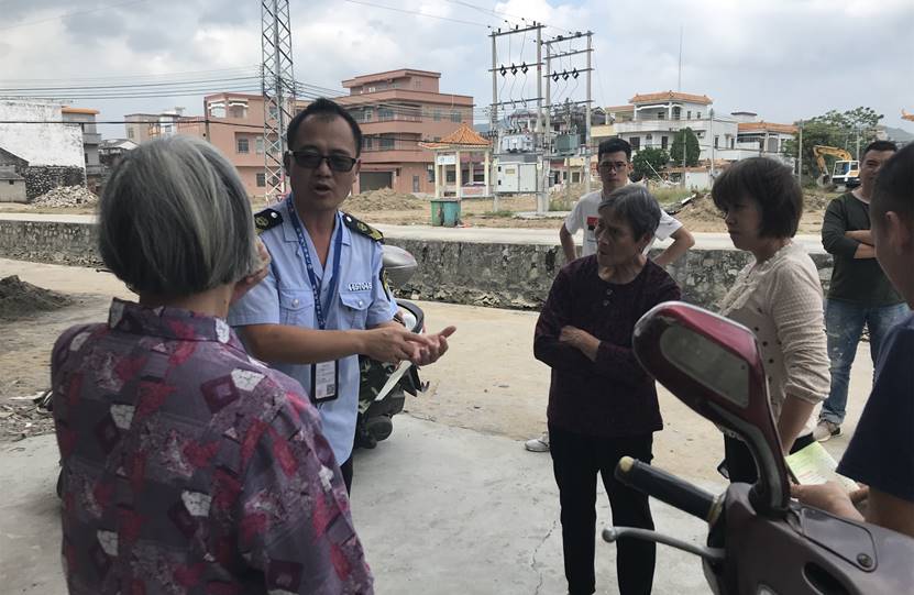 6工作人員對(duì)現(xiàn)場(chǎng)的群眾講解非法行醫(yī)的危害